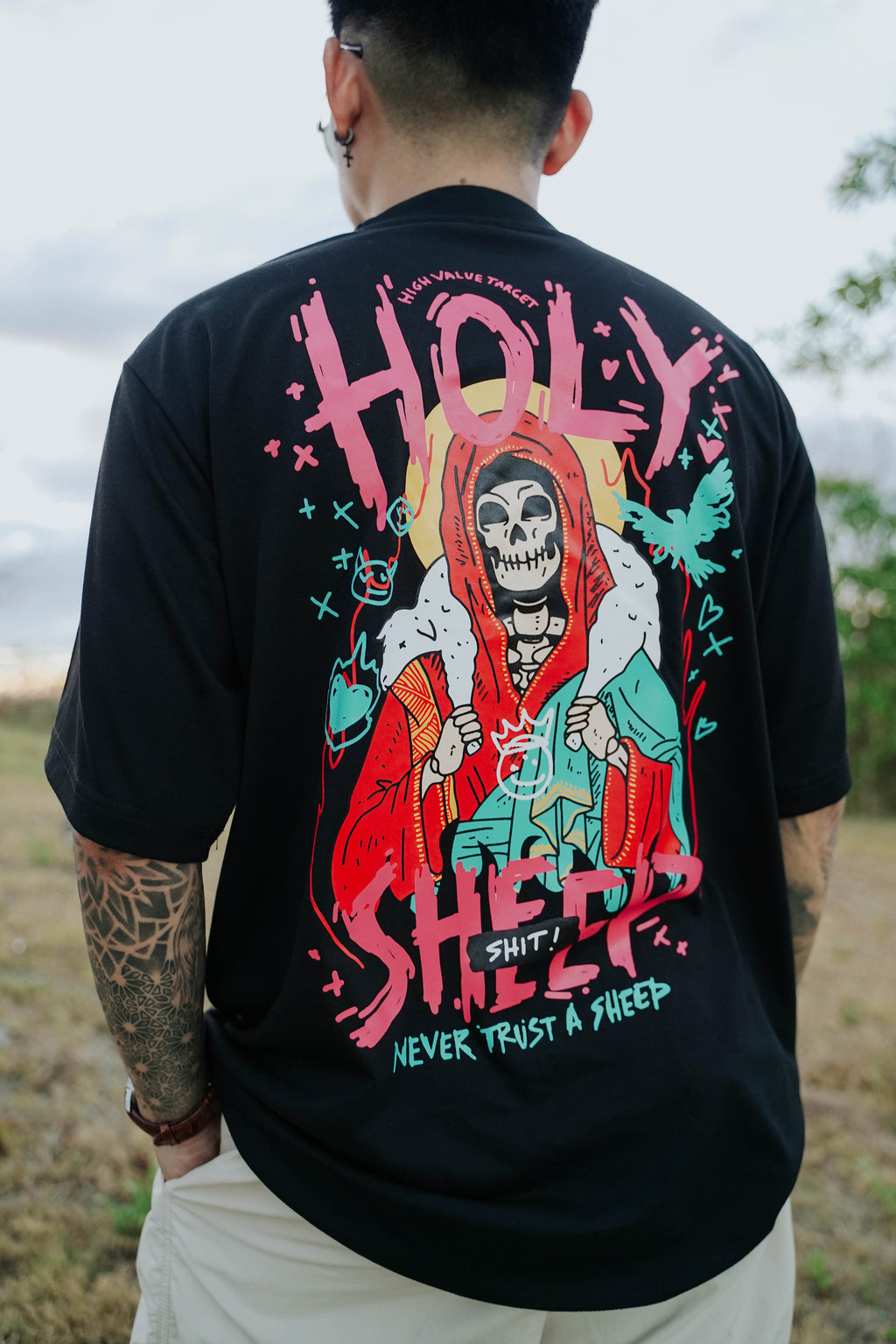 Graphic t-shirt featuring skeleton carrying sheep on back with never trust the sheep text, bold streetwear design