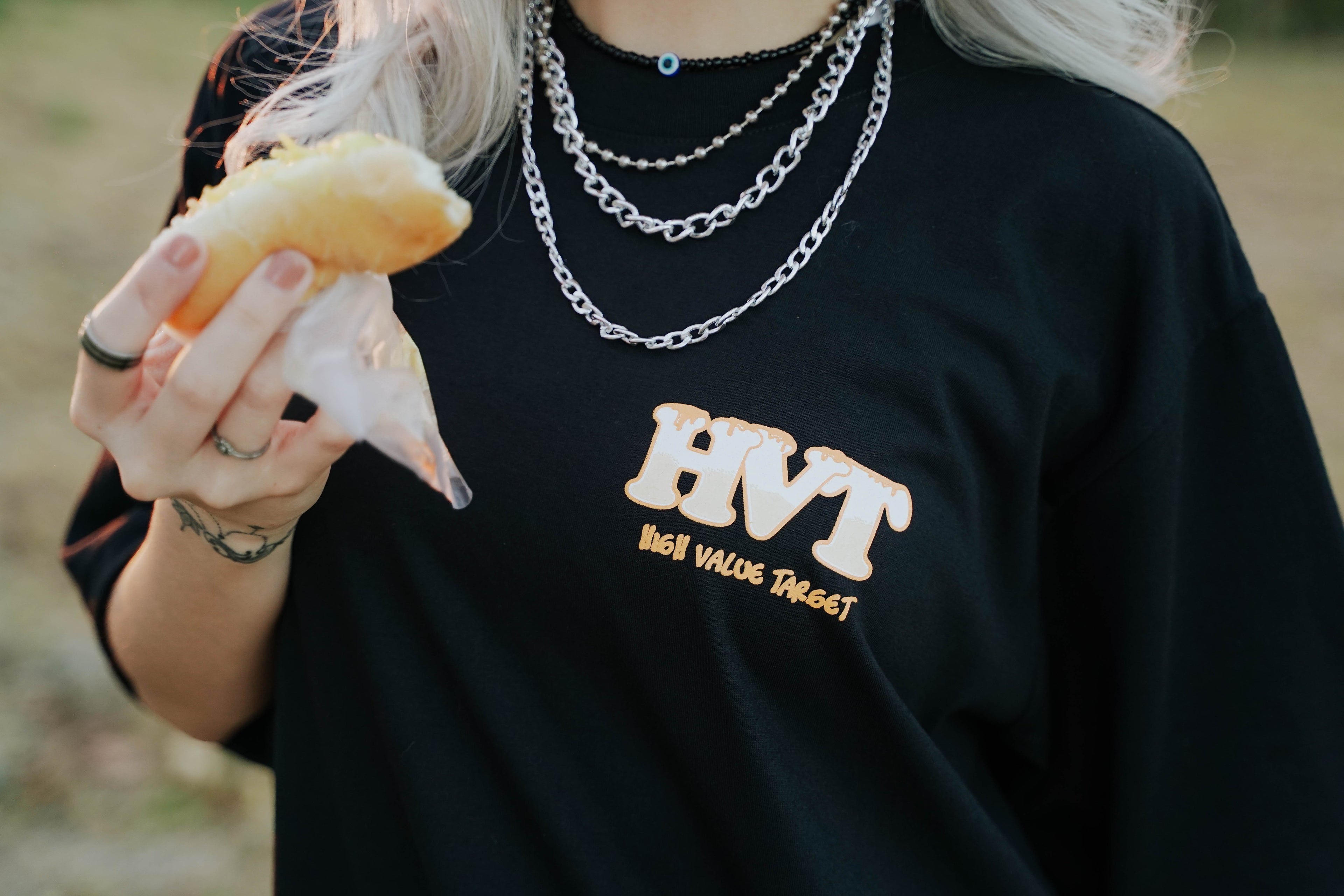 Black graphic T shirt with bold HVT typography for streetwear outfit styling