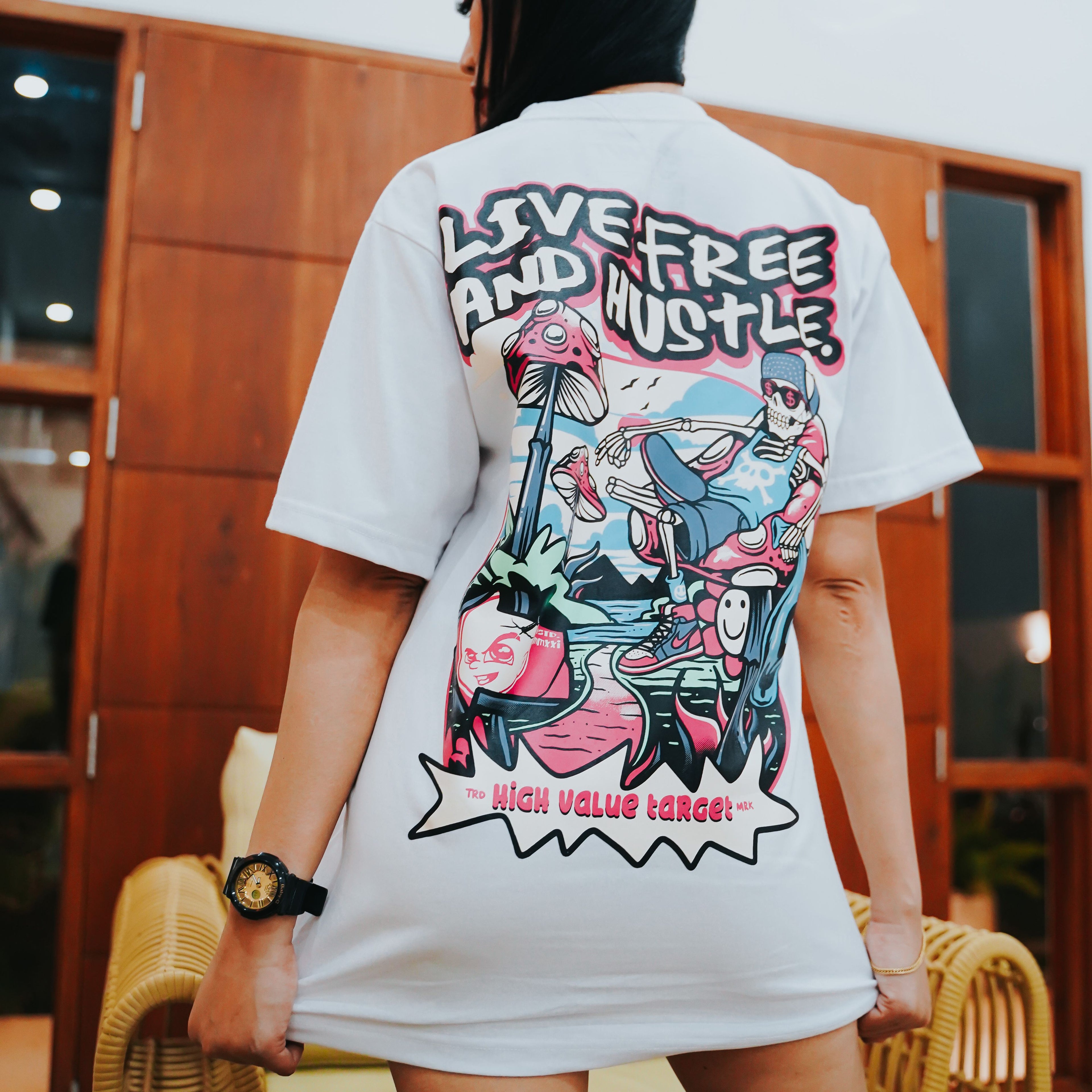 Edgy streetwear tee with relaxed skeleton holding money, mushroom elements and Live Free and Hustle phrase
