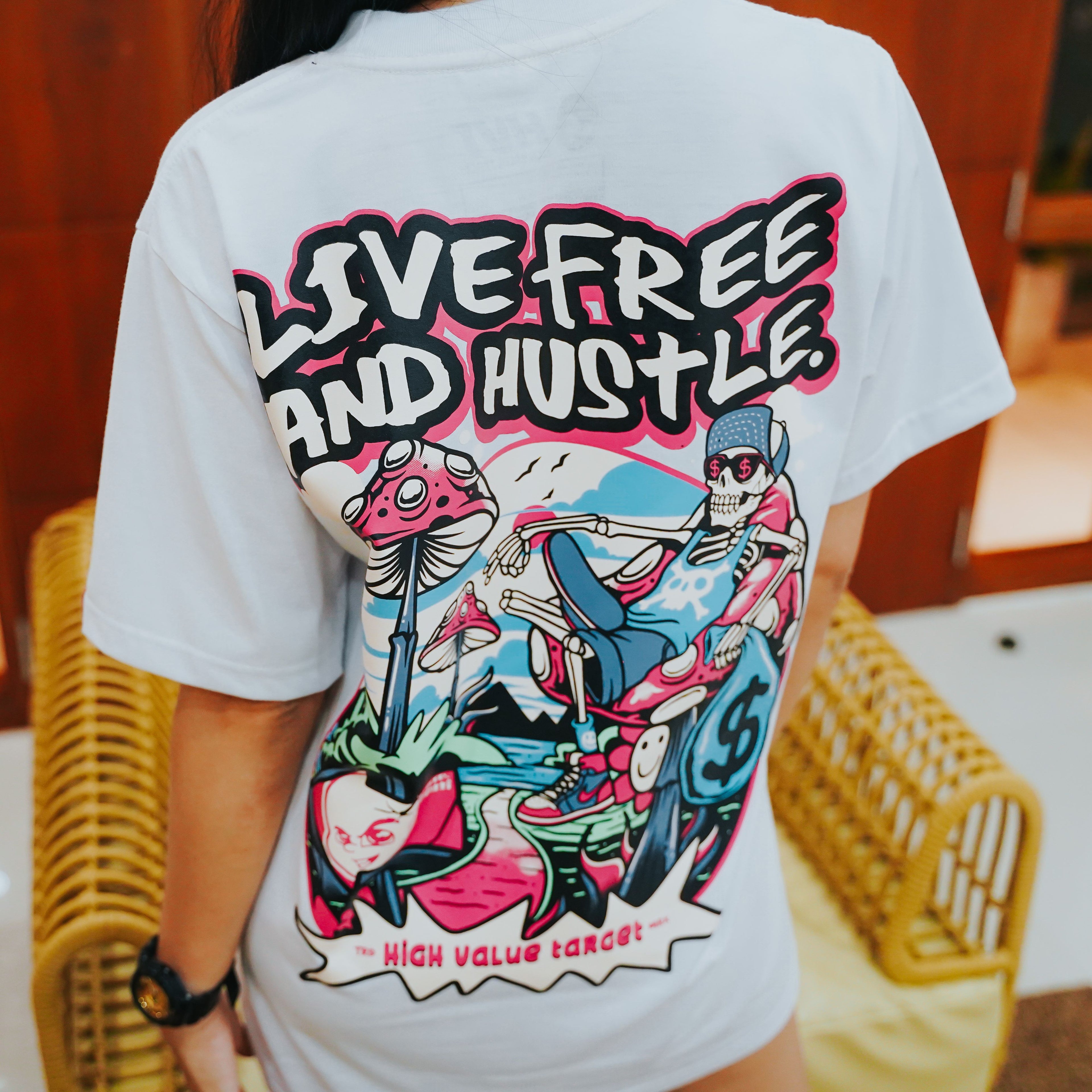 Black graphic tee showing relaxed skeleton with cash and mushrooms, Live Free and Hustle slogan in bold design